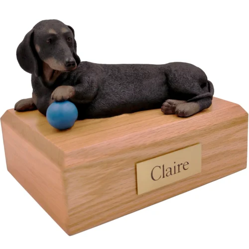 Memorial cremation urn with laying Black Dachshund with blue ball dog figurine, oak finish
