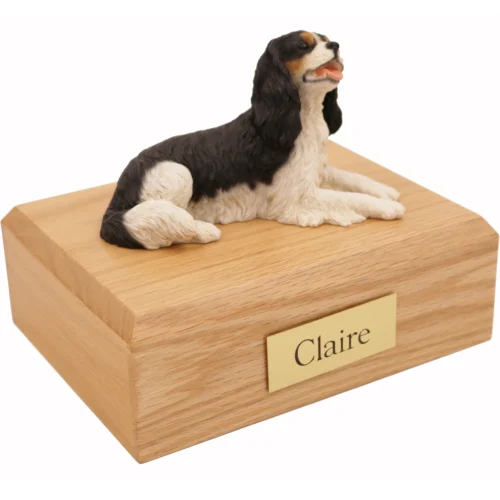 Memorial cremation oak finish urn with laying black and white King Charles Spaniel dog figurine