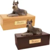 Budget dog figurine cremation urn, oak or walnut, with laying black & silver ears up Schnauzer figurine, engraved brass plaque