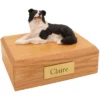 Memorial cremation urn with laying border collie dog figurine