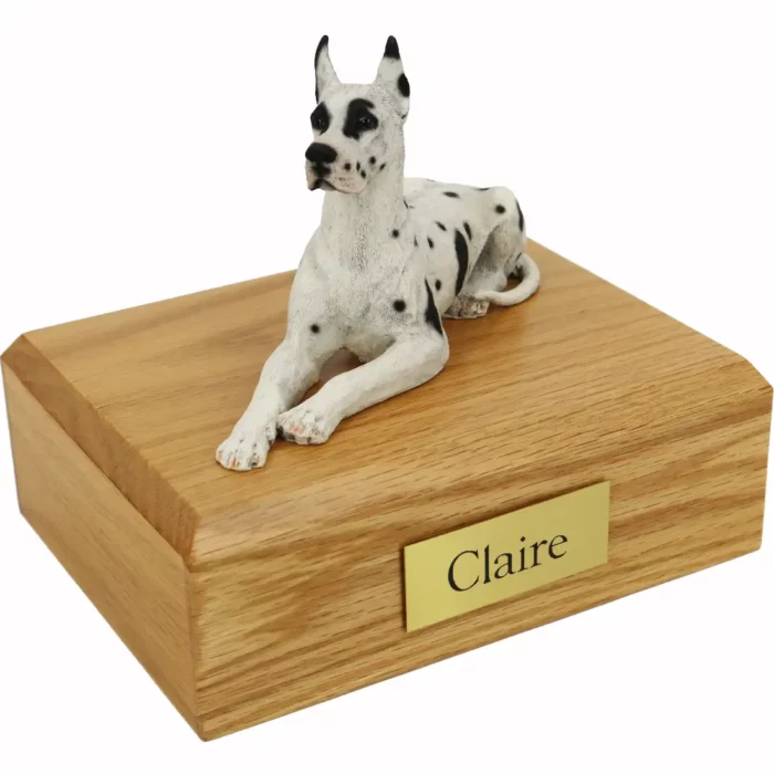 Laying Harlequin Great Dane dog figurine on wood memorial cremation urn