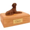 Laying chocolate labrador retriever dog figurine on wood memorial cremation urn