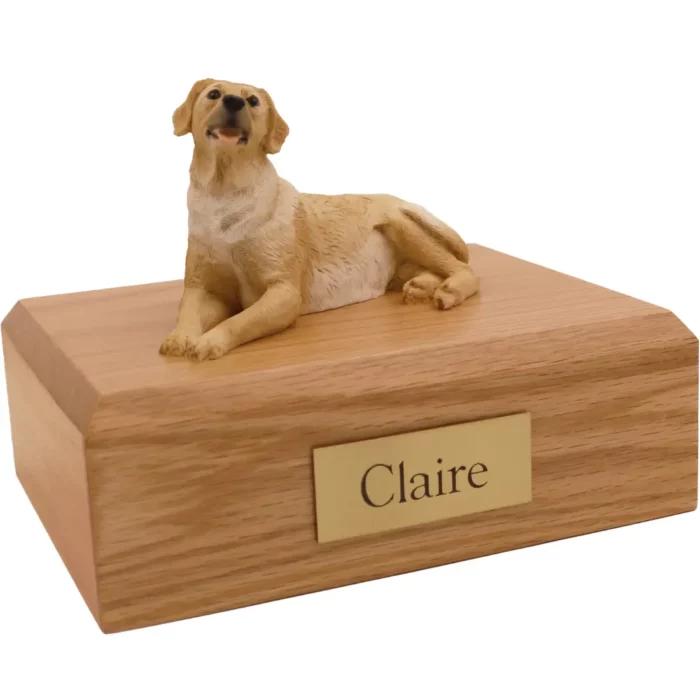 Laying golden labrador dog figurine on wood memorial cremation urn