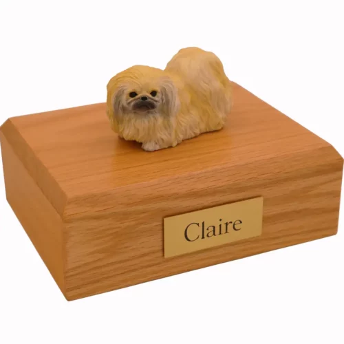 Laying Pekingese dog figurine on wood memorial cremation urn