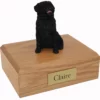 Sitting black pug dog figurine on wood memorial cremation urn