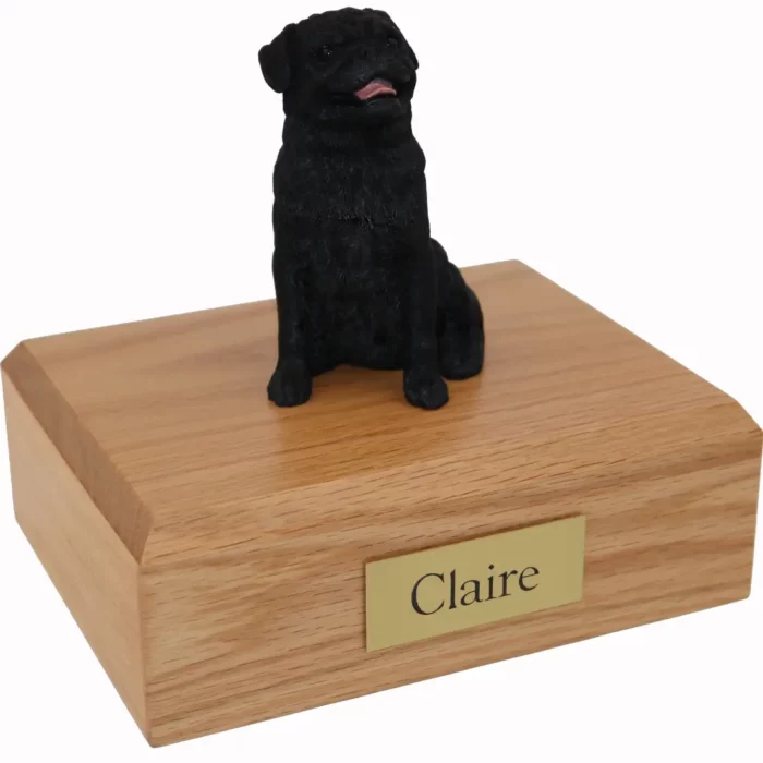 Sitting black pug dog figurine on wood memorial cremation urn