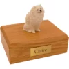 Sitting white pomeranian dog figurine on wood memorial cremation urn