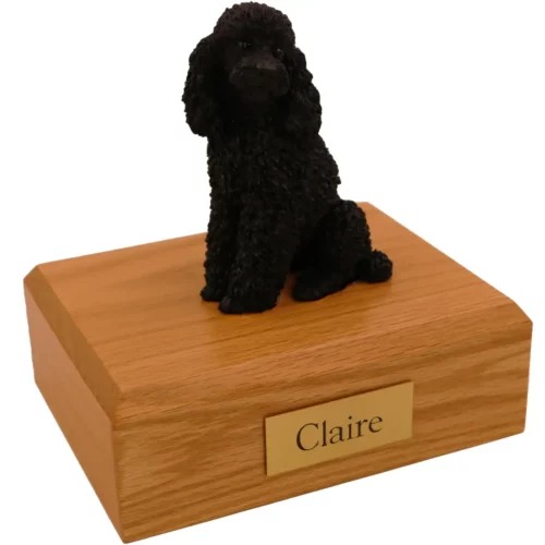 Sitting black poodle dog figurine on wood memorial cremation urn