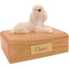 Laying white poodle dog figurine on wood memorial cremation urn