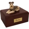 Sitting silver and white schnauzer dog figurine on wood memorial cremation urn