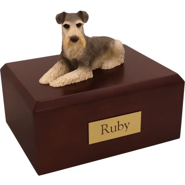 Sitting silver and white schnauzer dog figurine on wood memorial cremation urn