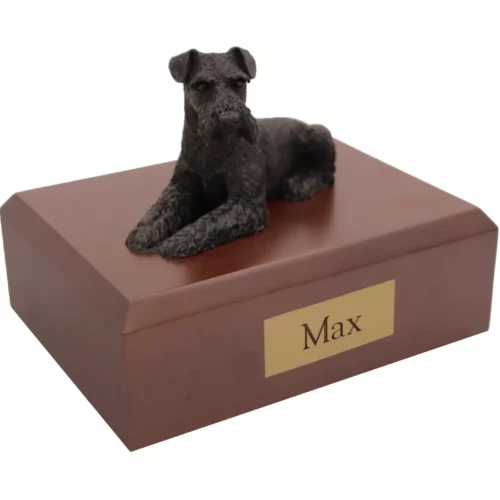 Laying black ears down schnauzer dog figurine on wood memorial cremation urn