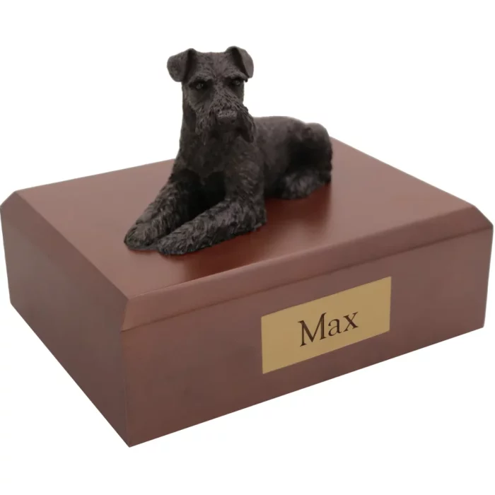 Laying black ears down schnauzer dog figurine on wood memorial cremation urn