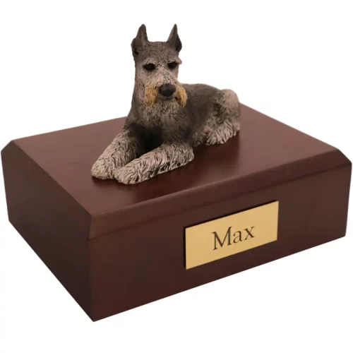 Laying black ears up schnauzer dog figurine on wood memorial cremation urn