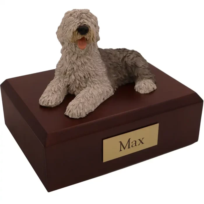 Laying sheepdog dog figurine on wood memorial cremation urn