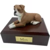 Laying ears down boxer dog figurine on wood memorial pet cremation urn