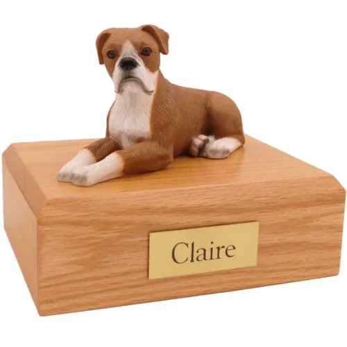 Laying ears down boxer dog figurine on wood memorial pet cremation urn