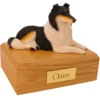 Laying tricolor collie dog figurine on wood memorial pet cremation urn