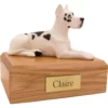 Laying ears up harlequin great dane dog figurine on wood memorial pet cremation urn