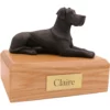 Laying ears down black great dane dog figurine on wood memorial pet cremation urn