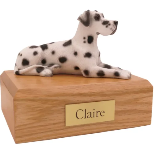 Laying ears down harlequin great dane dog figurine on wood memorial pet cremation urn