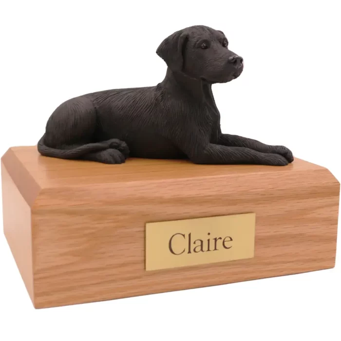 Laying black labrador dog figurine on wood memorial pet cremation urn