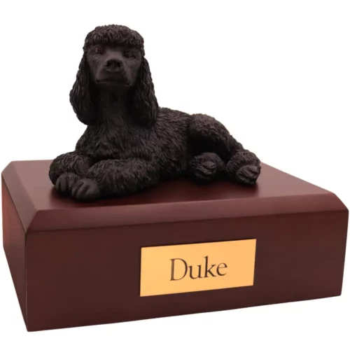 Laying black poodle dog figurine on wood memorial pet cremation urn