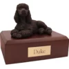 Laying bronze look poodle dog figurine on wood memorial pet cremation urn