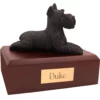 Laying bronze look ears up schnauzer dog figurine on wood memorial pet cremation urn