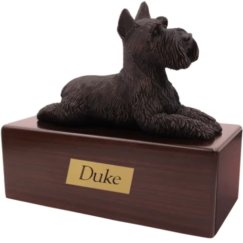 Laying bronze look ears up schnauzer dog figurine on wood memorial pet cremation urn