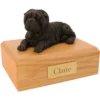 Laying black shar pei dog figurine on wood memorial pet cremation urn