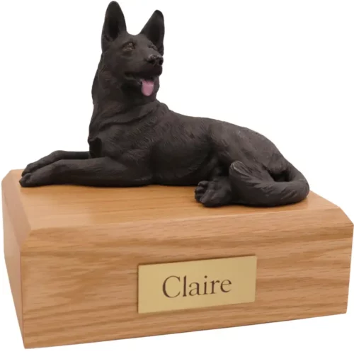 Laying black German Shepherd dog figurine on wood memorial pet cremation urn