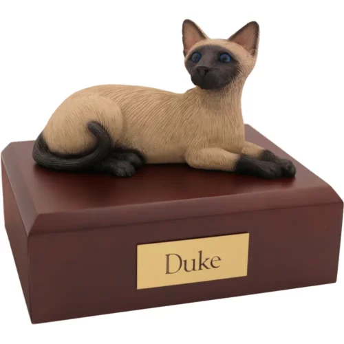 Laying Siamese cat figurine on wood memorial pet cremation urn