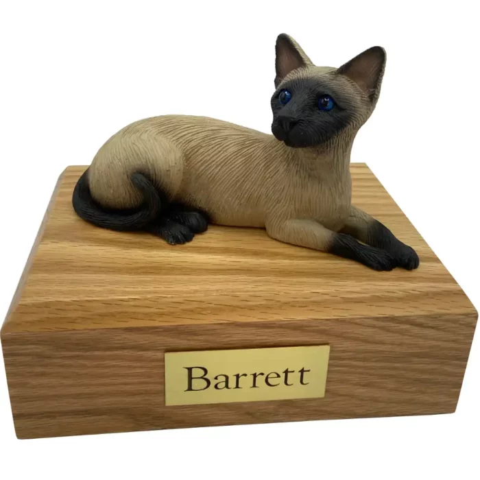 Laying Siamese cat figurine on wood memorial pet cremation urn