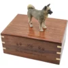 Gray akita dog figurine on wood cremation urn, engraved wood