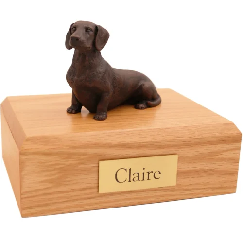 Sitting dachshund bronze look dog figurine on wood cremation urn