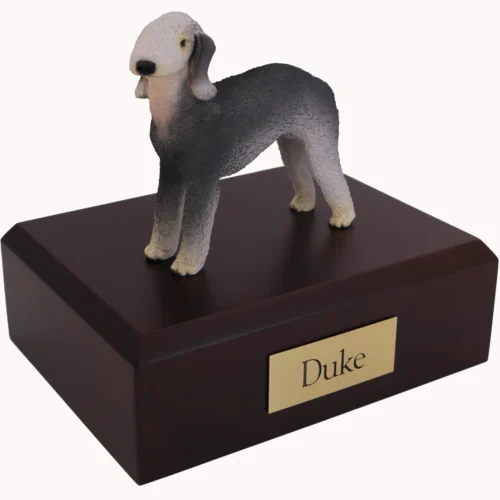 Standing gray and white bedlington terrier dog figurine on wood cremation urn