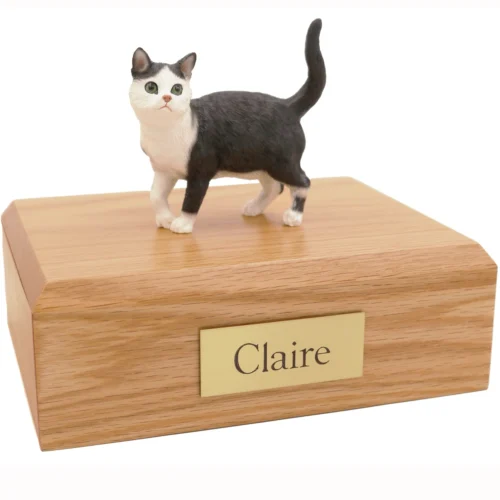 Standing shorthair black and white tuxedo tabby cat figurine on wood cremation urn