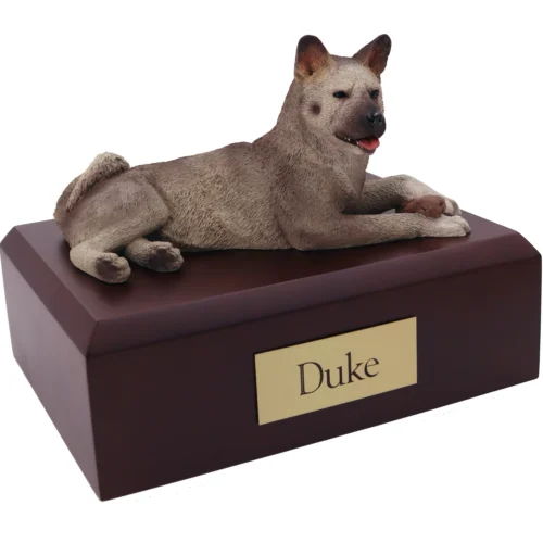 Laying gray Akita dog figurine on wood cremation urn