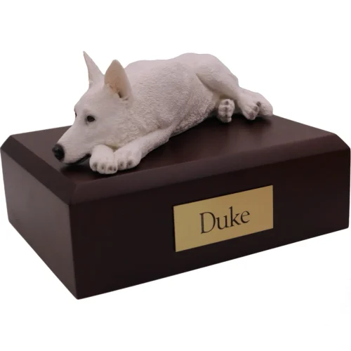 Laying white German Shepherd dog figurine on wood cremation urn