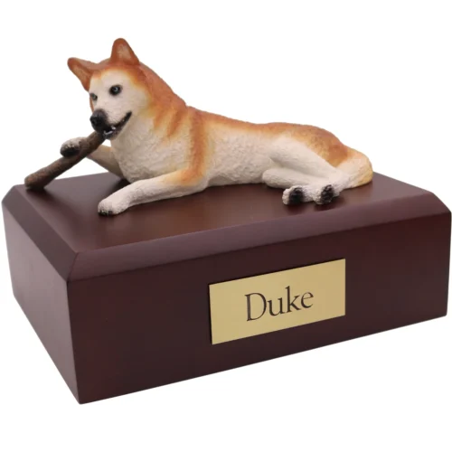 Red and white Husky with stick dog figurine on wood cremation urn