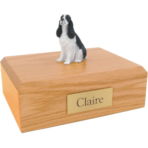 Black and white springer spaniel dog figurine on wood cremation urn