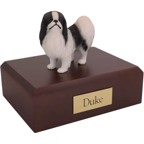 Standing black and white Japanese Chin dog figurine on wood cremation urn