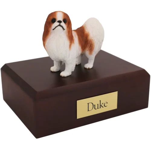 Standing red and white Japanese Chin dog figurine on wood cremation urn