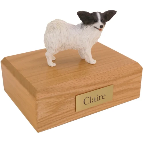 Standing black and white papillion dog figurine on wood cremation urn