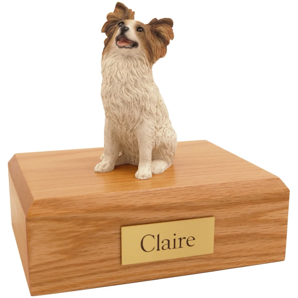 Sitting papillon dog figurine on wood cremation urn