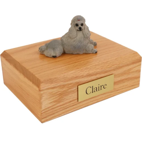 Laying Gray Poodle dog figurine on wood cremation urn