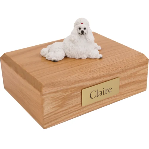Laying White Poodle dog figurine on wood cremation urn
