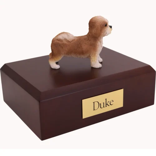 Standing tan and white puppycut shih tzu dog figurine on wood cremation urn