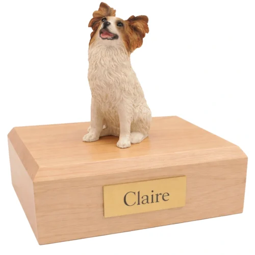 Memorial cremation urn with sitting brown and white Papillon dog figurine, maple finish